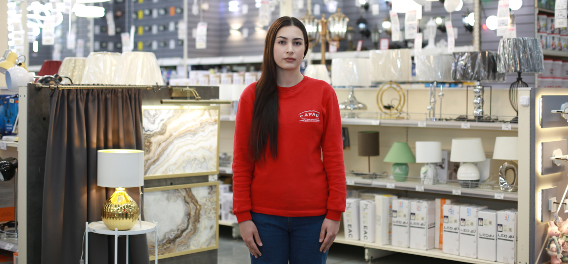 prodavets-konsultant-saray-v-otdele-osveshcheniya-ryadom-s-nastolnymi-lampami