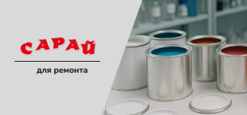 На столе стоят открытые банки с фасадной краской разных цветов и цветовая палитра с образцами оттенков.