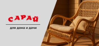 Кресло-качалка из натурального ротанга с мягкой подушкой на веранде в солнечных лучах