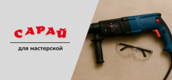 Строительный перфоратор с буром и защитные очки на рабочей поверхности