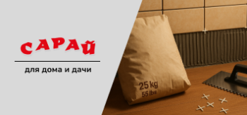 Мешок плиточного клея на полу у стены с частично уложенной плиткой, рядом зубчатый шпатель и плиточные крестики