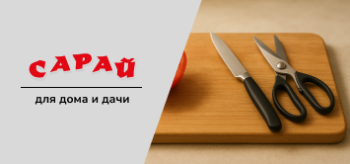 Разрезанный помидор на деревянной доске, рядом аккуратно лежат нож с тонким лезвием и кухонные ножницы на тёплом фоне