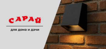 Компактный фасадный светильник, закреплённый на кирпичной стене, направленный тёплый свет вниз, виден тип крепления и структура поверхности