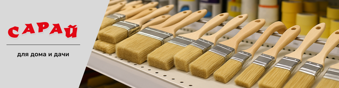 Витрина строительного магазина с малярными кистями разных размеров на переднем плане и красками на заднем плане