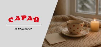 Чайная пара с сердечками стоит на вязаном пледе у окна, рядом свеча и открытка, за окном — заснеженный пейзаж