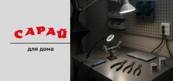 Рабочий стол в мастерской с инструментами, паяльником, лампами и перфорированной панелью для хранения инструментов