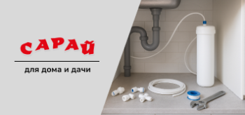 Установленный фильтр для воды под кухонной мойкой, подключённые трубки, на полу аккуратно разложены фитинги, фум-лента и гаечный ключ