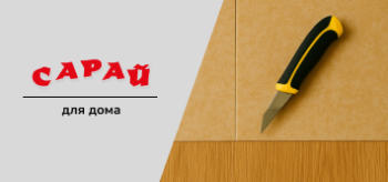 Канцелярский нож с черно-желтой ручкой лежит на стыке напольных покрытий — линолеума и ламината